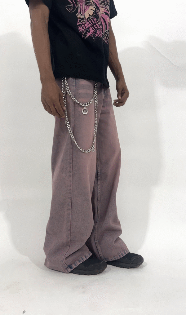 Wide-leg dust rose pants with a relaxed fit and vintage-washed finish, styled with a black graphic t-shirt and chunky sneakers.